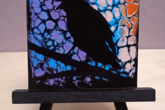 Crow painting on easel