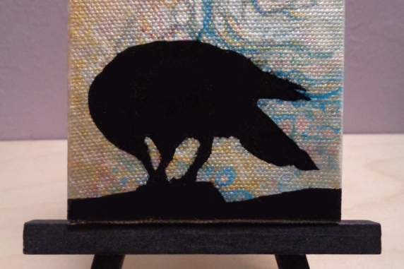 Crow painting on easel